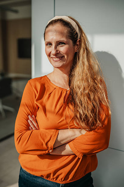 istock Confident businesswoman poses in modern office setting while promoting teamwork and success among colleagues 2246442558