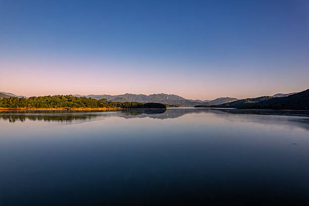 The morning lake is surrounded by forests