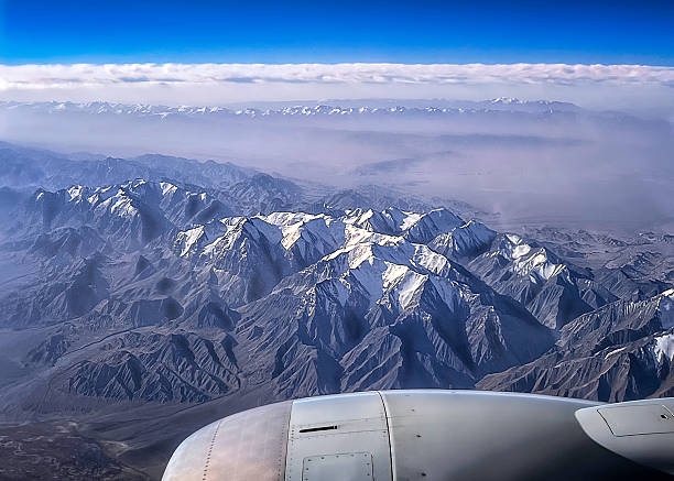 Airplane flew over snow-capped mountains and glaciers