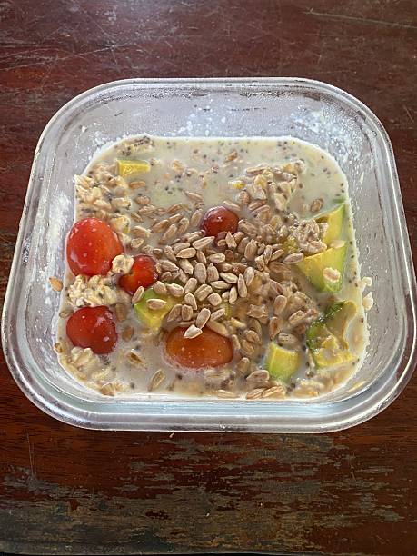 Oatmeal with fruit and vegetable in glass container on wooden table