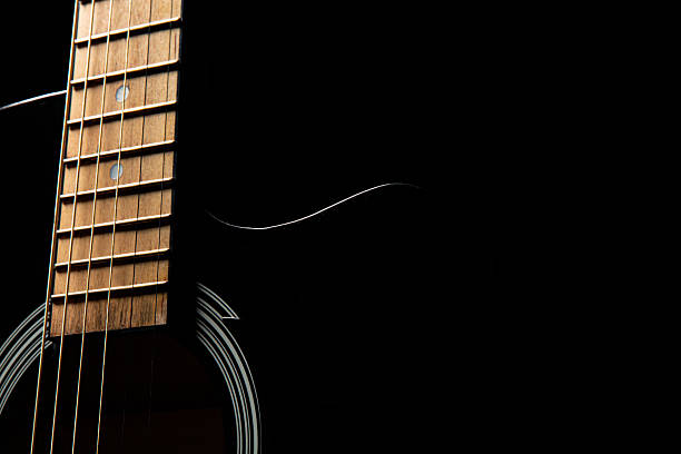 istock black acoustic guitar on a black background, silhouette 2246448842