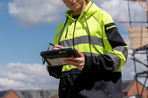 istock Young woman construction worker using a tablet for site management on a sunny day 2246454477