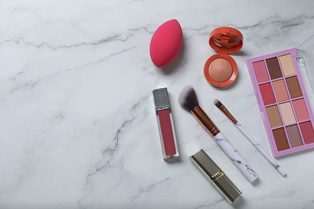 istock Cosmetics on a marble background. Cosmetic palette, brushes, creams and lipsticks. Top view. 2246461483