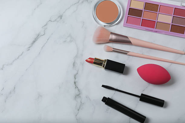 istock Cosmetics on a marble background. Cosmetic palette, brushes, creams and lipsticks. Top view. 2246461485
