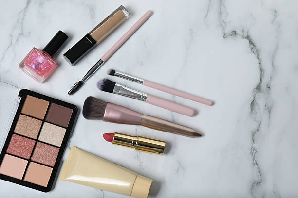istock Cosmetics on a marble background. Cosmetic palette, brushes, creams and lipsticks. Top view. 2246461502