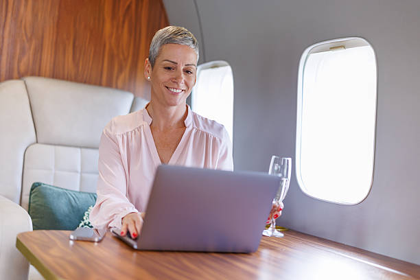 istock Businesswoman flying private jet working on laptop 2246462151