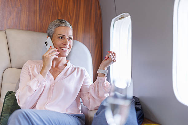 istock Businesswoman talking on phone flying private jet 2246462160