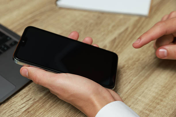 istock Man using smartphone with blank screen at wooden table, closeup 2246462891