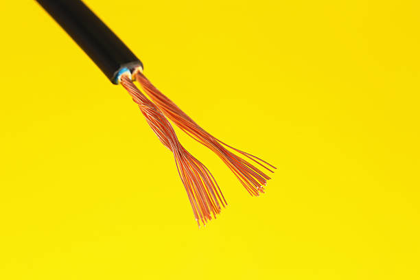 Black stripped electrical wire on yellow background, closeup