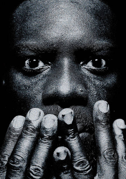 Black-and-white portrait in extreme close-up, hands covering the mouth, raw lighting and cinematic grain.