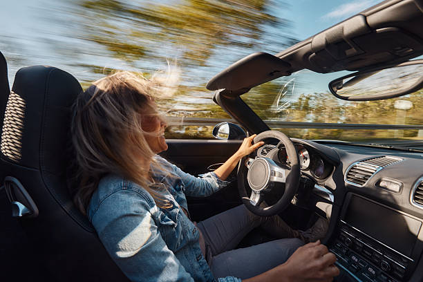 istock Happy woman enjoying while driving a convertible car. 2246467790