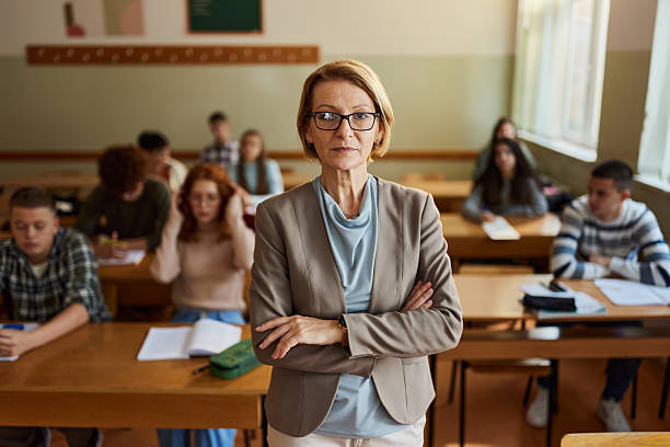 istock Senior teacher with crossed arms in the classroom. 2246468737
