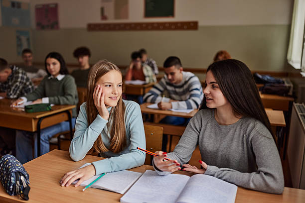 istock Smiling female students talking on a class at high school. 2246468823