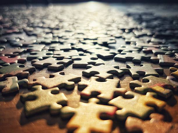 The jigsaw puzzle in the afternoon light. Copy space. Unfinished jigsaw. Puzzle pieces scattered.