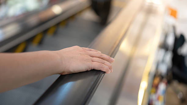 istock People hand is holding on the handrail during riding escalator. 2246469649