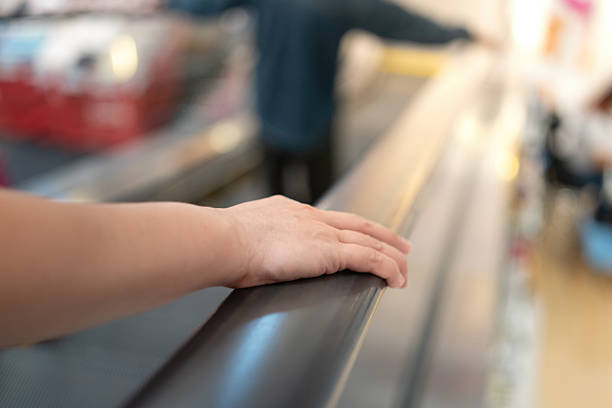 istock People hand is holding on the handrail during riding escalator. 2246469651