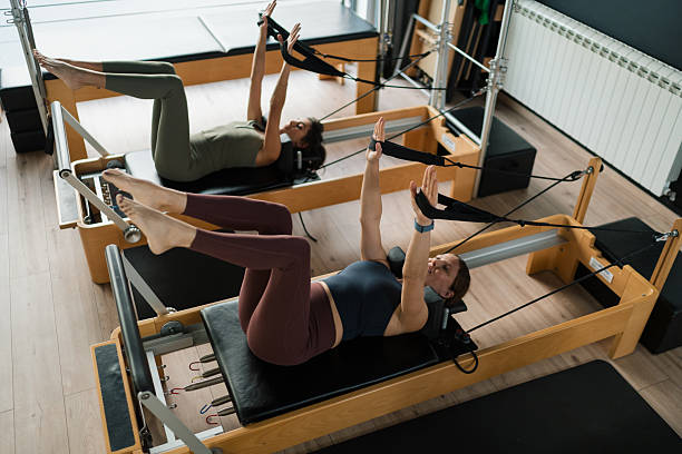 istock Women training pilates on reformer machines in studio 2246470331
