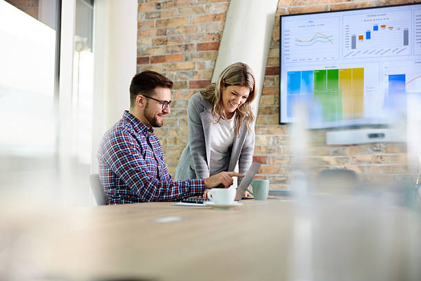 istock Happy business colleagues using laptop in the office. 2246470540