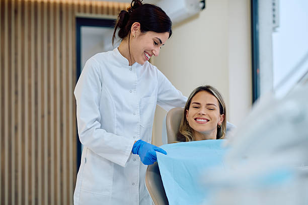 istock Dentist consulting patient after dental check-up showing satisfaction 2246473995
