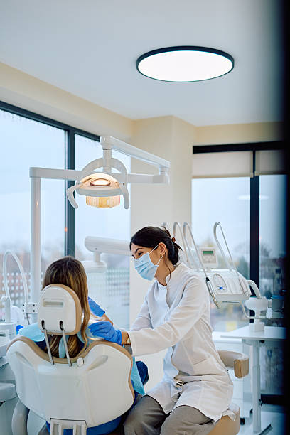 istock Female dentist examining patient in modern dental office 2246474064