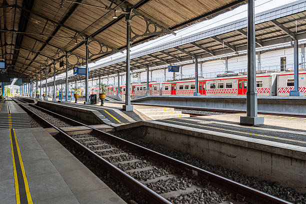 istock Modern Railway Station Platform with Red Commuter Train under Metal Roof 2246474702