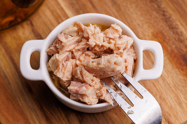 istock Classic canned tuna in oil on rustic wooden table 2246474781