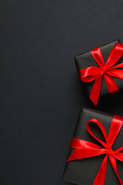 istock Vertical view of gift boxes tied with bows on black background 2246475036