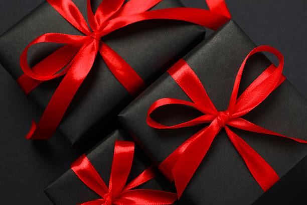 istock Beautiful gift boxes tied with bows on black background 2246475037