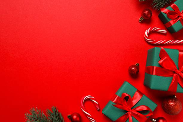 istock Beautiful gift boxes tied with red bows and Christmas decorations on color background 2246475151