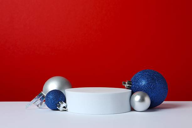 istock A front view of an empty podium decorated with balls on red background. Christmas concept, product presentation space. 2246475200