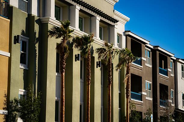 istock Modern Mediterranean-Style Residential Buildings with Palm Trees under Clear Blue Sky 2246475302