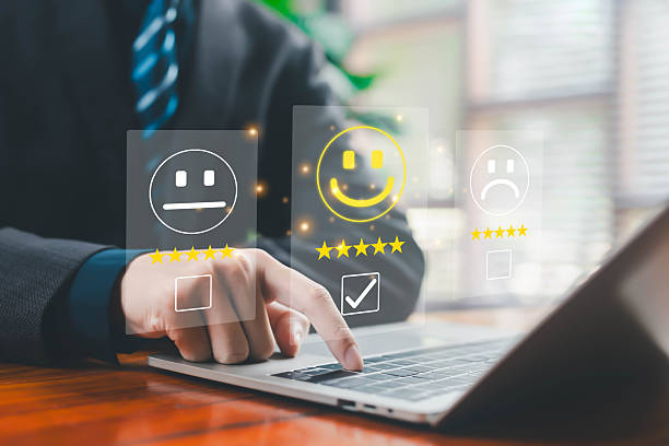 istock Business person using laptop to select positive customer feedback with digital smiley icons, five-star rating, and satisfaction evaluation interface representing user experience, service quality, and 2246476123