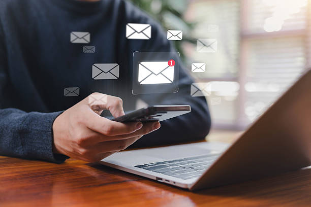istock Person checking email notifications on a smartphone beside a laptop, illustrating mobile communication, digital messaging, online workflow, and modern productivity in a connected work environment. 2246478189