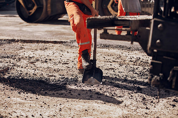 istock Construction workers working on a new asphalt layer on a public street. 2246481063
