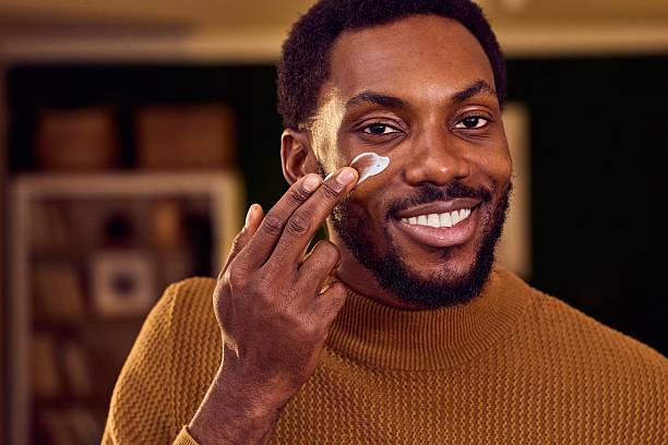 istock Smiling Man Applying Eye Cream In Cozy Home For Skincare Routine 2246481613