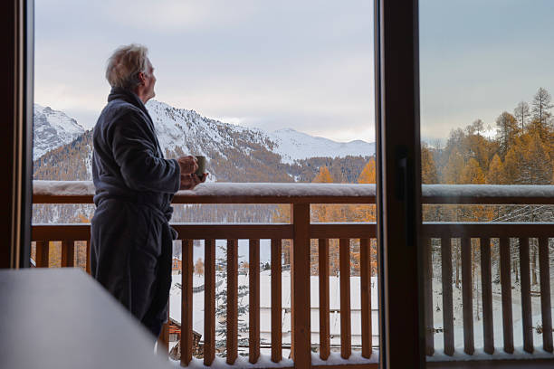 istock Man enjoys hot beverage on chalet deck in fresh snow 2246483700