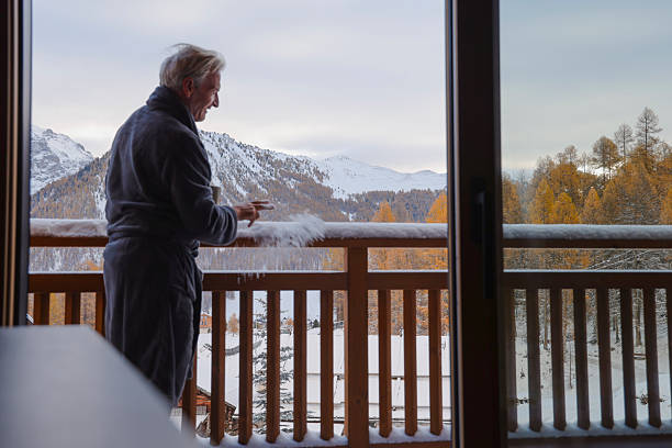 istock Man in bathrobe stands on chalet deck in fresh snow 2246483701