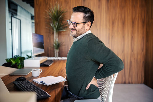 istock Businessman suffering from lower back pain at office desk 2246485588