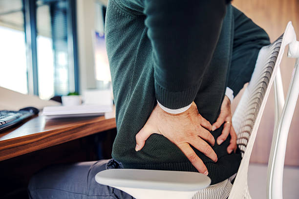 istock Man experiencing back pain working at office desk 2246485594