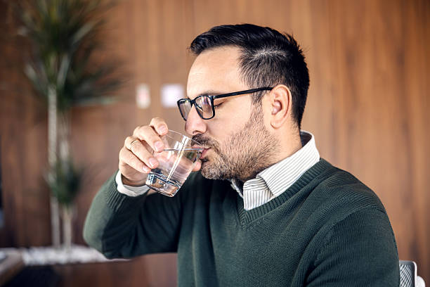 istock Young adult man drinking water in office 2246485622