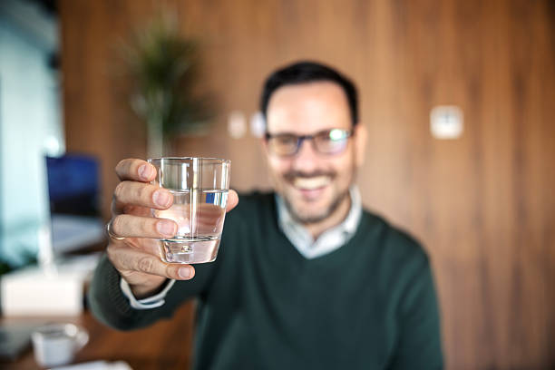 istock Man offering glass of water for hydration 2246485639