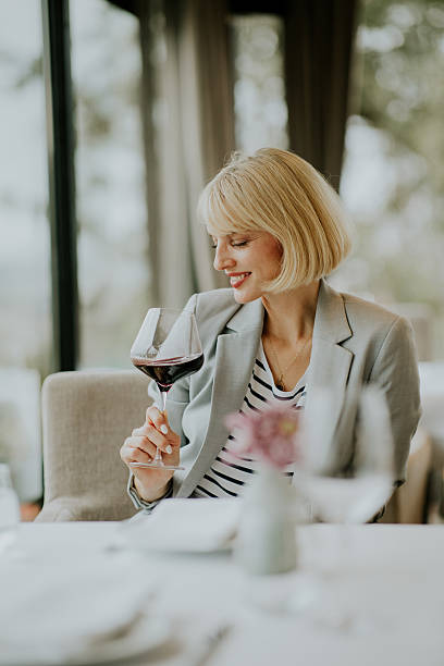 istock Woman enjoys red wine while seated at a charming restaurant with a view on a pleasant day 2246485685