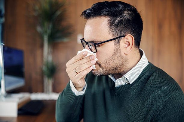 istock Adult man blowing nose working from home office 2246485714