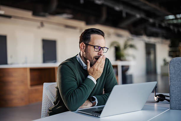 istock Tired businessman yawning during long work day 2246485807