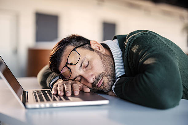 istock Tired businessman napping on laptop at workplace 2246485819