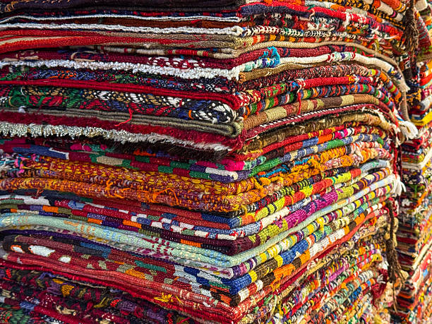 istock Neatly stacked colorful handmade Turkish carpets on display at a bazaar 2246486950