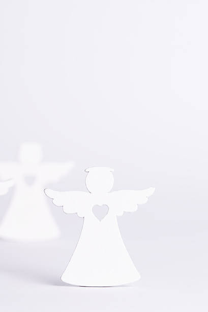 Angel sitting on the floor while yellow light is shinning above her.