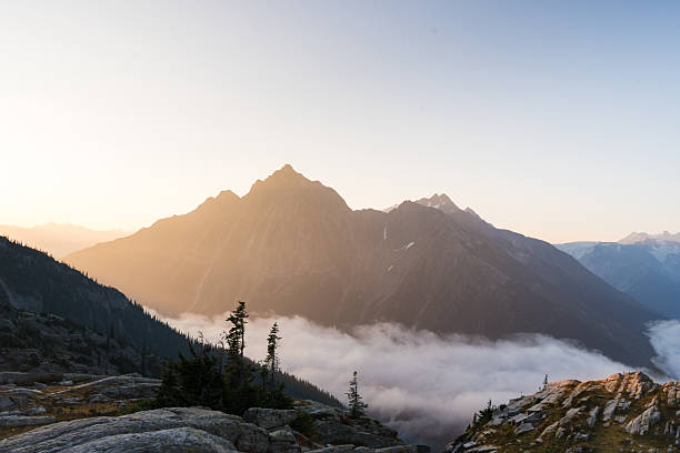 istock Golden hour paints a scenic mountain range, framed by clouds and a clear sky. 2246490889