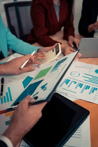 istock Businessman and team analyzing statistics with documents and graphs. Accounting consultant dealing with data, budget and profit chart for company. Close up. 2246495656