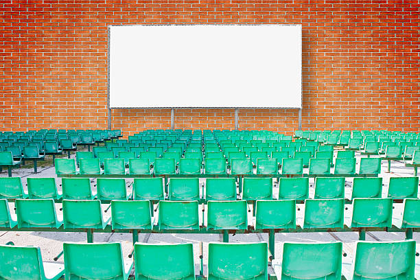 istock Outdoor cinema with chairs and white projection screen against a brick wall - concept image 2246496838